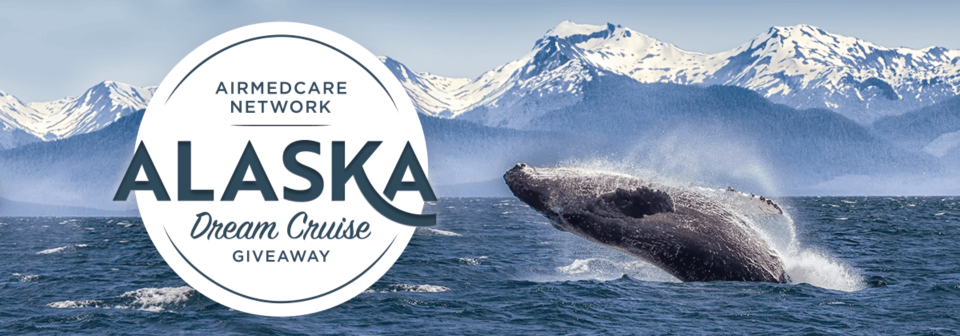 AirMedCare Network Alaska Dream Cruise Giveaway. Whale breaking the water in front of the Alaskan mountains.